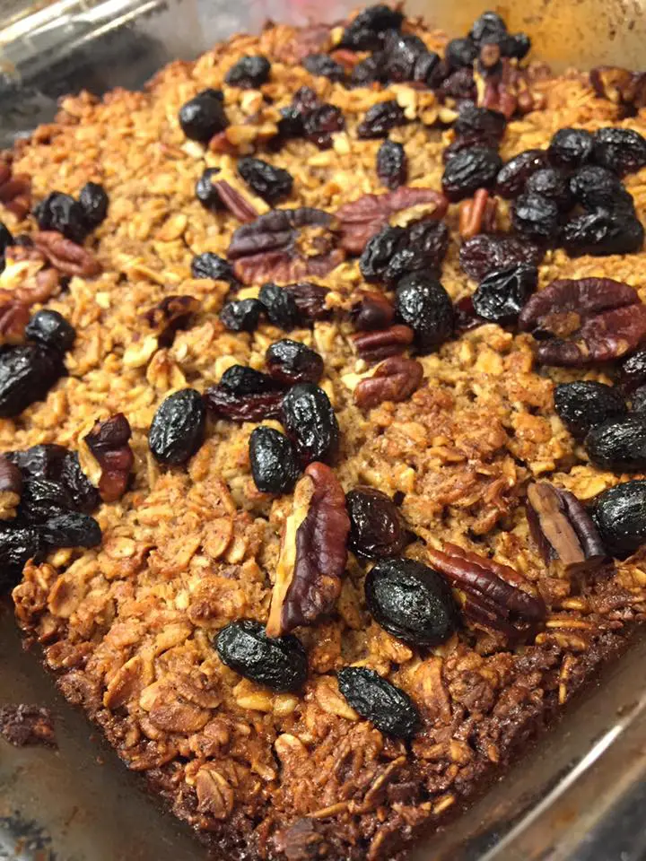 close up of homemade baked oatmeal decorated with raisins, craisins and pecans